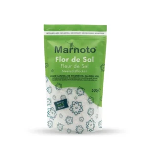 Sachet doypack vert et blanc de 500 g de fleur de sel artisanale Marnoto, 100% naturelle et récoltée à la main au Portugal. L'emballage est illustré de motifs floraux géométriques et d'une fenêtre transparente révélant de delicats cristaux de fleur de sel.