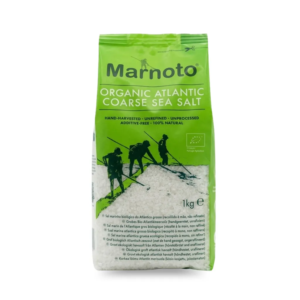 Sachet vert de 1 kg de gros sel marin atlantique biologique Marnoto, non raffiné et récolté à la main. Le paquet transparent laisse voir de gros cristaux de sel naturel et arbore des silhouettes de paludiers traditionnels (marnotos) travaillant dans les salines.