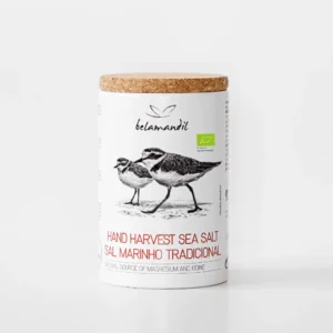 Tube cylindrique en carton blanc réutilisable avec bouchon en liège naturel, contenant 500 g de gros sel marin traditionnel biologique Belamandil. L'emballage contemporain présente une illustration dessinée de deux pleviers à collier interrompu (Charadrius alexandrinus) et le logo de la marque sur fond blanc.
