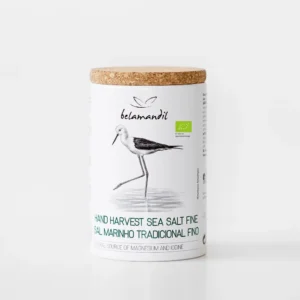 Tube cylindrique en carton blanc réutilisable avec bouchon en liège naturel, contenant 400 g de sel marin fin traditionnel biologique Belamandil. L'emballage contemporain présente une illustration dessinée d'un échassier échasse blanche (Himantopus himantopus) marchand dans l'eau et la mention du produit en vert.