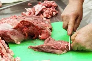 Découpe artisanale à la main de viande fraîche pour la fabrication de charcuterie traditionnelle Quintinha d'Aldeia.